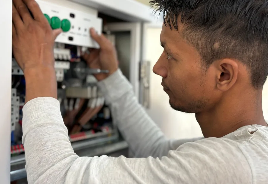 A Perth electrician on the job, working on a circuit-breaker switchboard